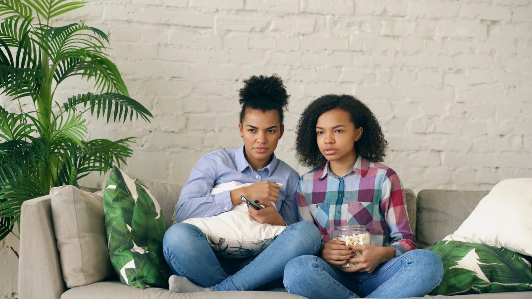 A mother and daughter watching a programme together at home