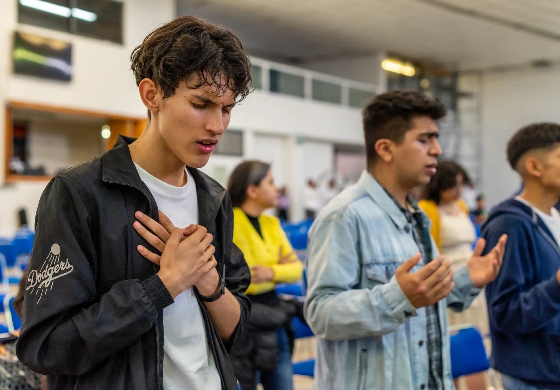 Young people praying together in a church gathering